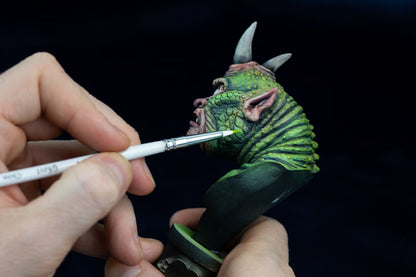Person painting a detailed figurine of a creature with a Ghost Paintbrush on a black background